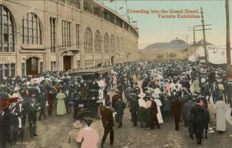 Colorized photograph of a large crowd of people standing in front of a huge Beaux Arts building…