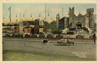 Colorized photograph of a dog, sheep and a man standing on a road in front of a very large buil ...