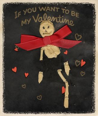 A skeleton made of ceramic or plaster has been affixed to the front of this card. Behind it is …