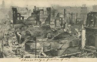 Black and white photo postcard depicting an elevated view of the area of Toronto damaged by the…