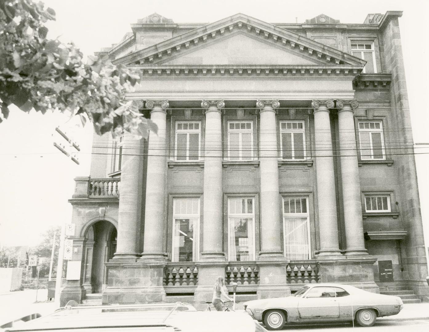 Picture of large stone library with pillars and corner entrance. 