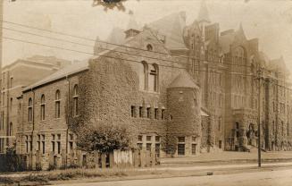 Black and white photograph of two very large late Victorian design buildings.