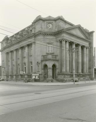 Picture of large stone library with pillars and corner entrance. 