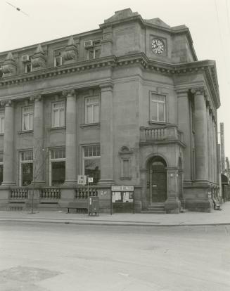 Picture of large stone library with pillars and corner entrance. 