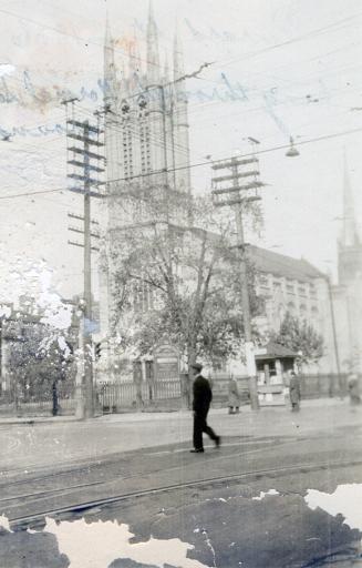 A photograph of a large church in a neo-gothic style, with tall towers and spires, beside a pav…