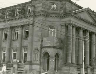 Picture of large stone library with pillars and corner entrance. 