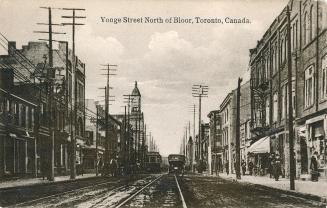 Sepia toned photograph of streetcars traveling on a busy city street with tall buildings on eit…