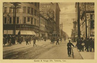 Sepia tones photograph of a very busy city street corner with automobiles and a streetcar. Poli…