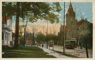 Colorized photograph of streetcars running along a wide city street. Houses on the left. and a …