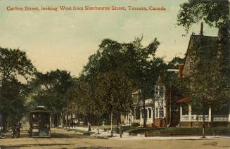 Colorized photograph of streetcars running along a wide city street. Houses on the right hand s…