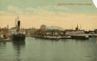 Colorized photograph of a steam boasts sailing in front of busy docks.