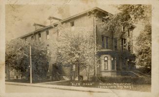 Black and white photograph of a three story building with bay windows at the front.