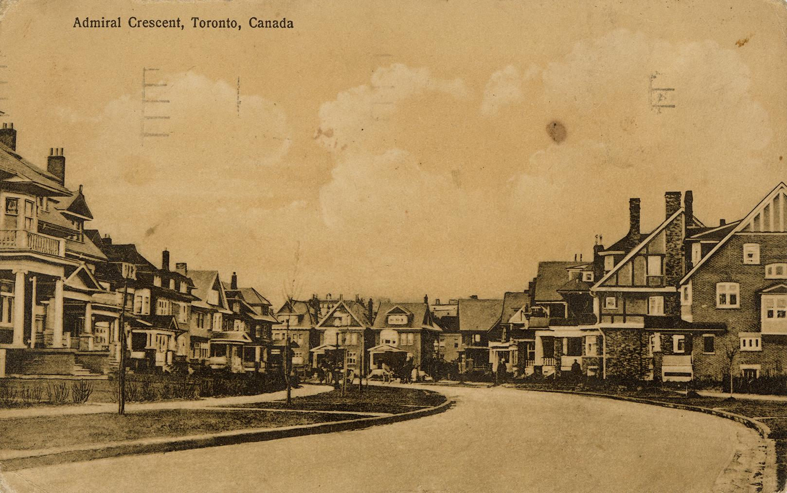 Black and white photograph of a large house on either side of a curved street.