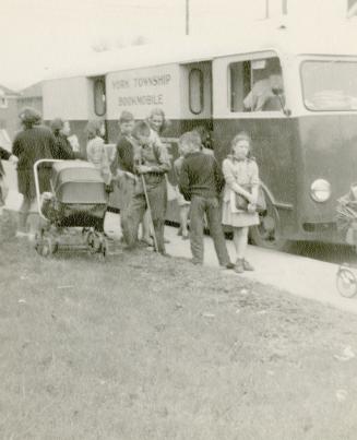 Picture of children lined up at a bookmobile. 