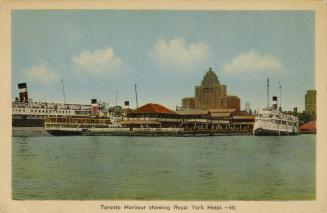 Colorized photograph of steam boats moored in front of busy docks. Very large hotel is in the b…