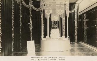 Black and white photograph of a crown decoration in a display in the interior of a department s…