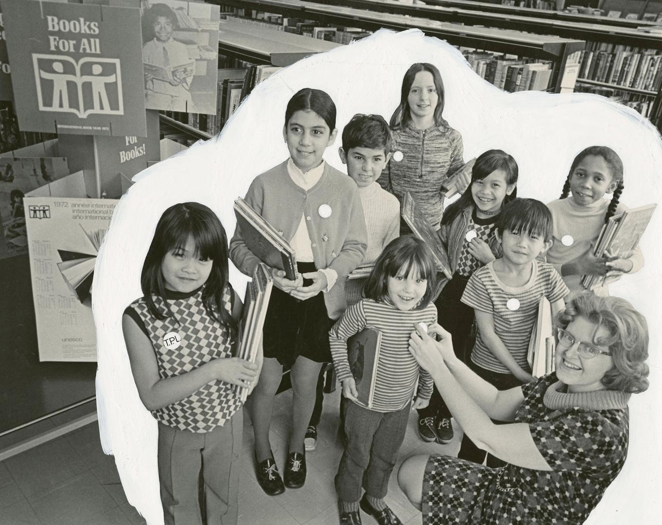 Picture of a group of children in a library and a librarian pinning a button on one child's shi…