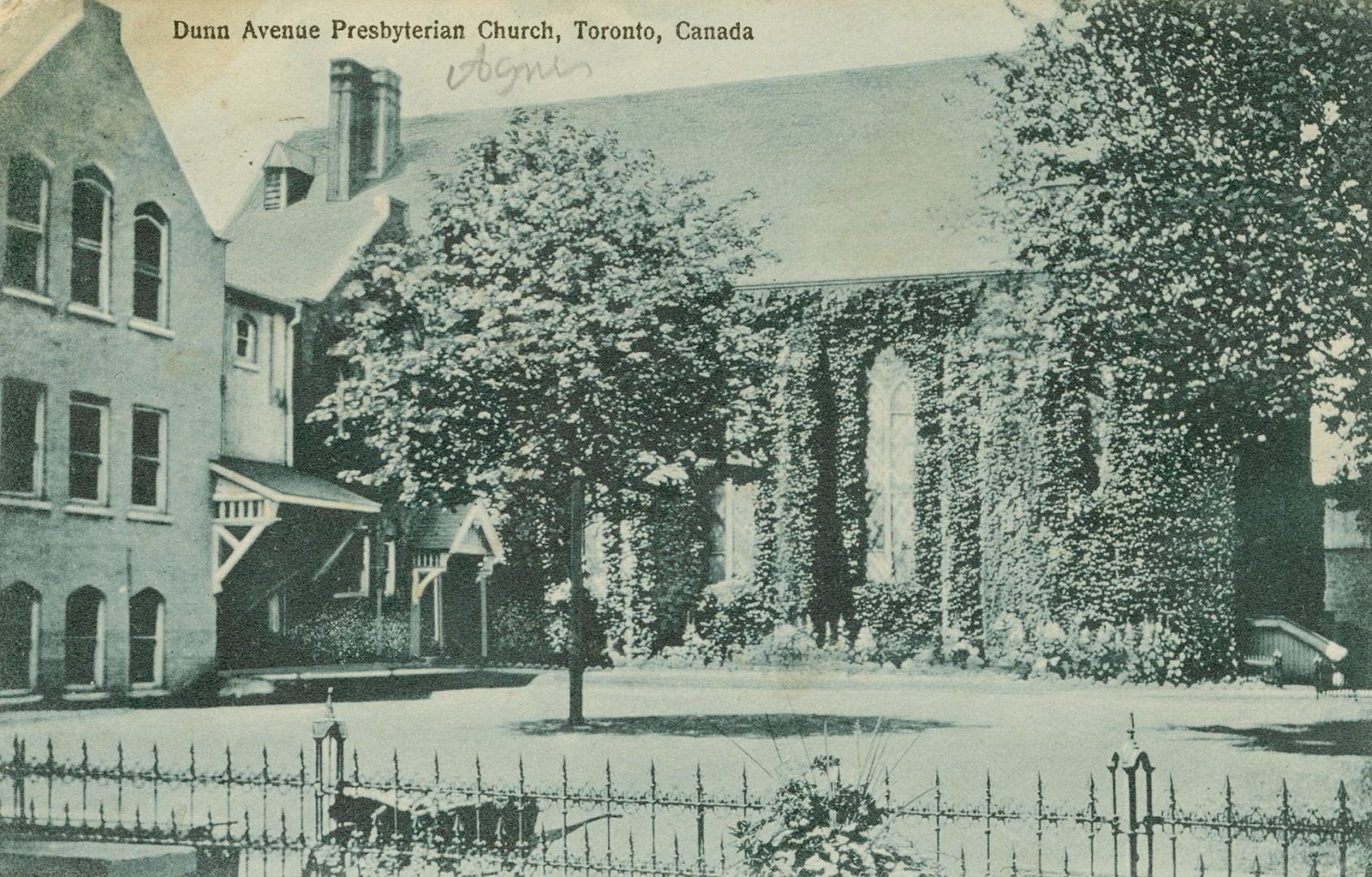 Black and white photograph of a large church covered with ivy.