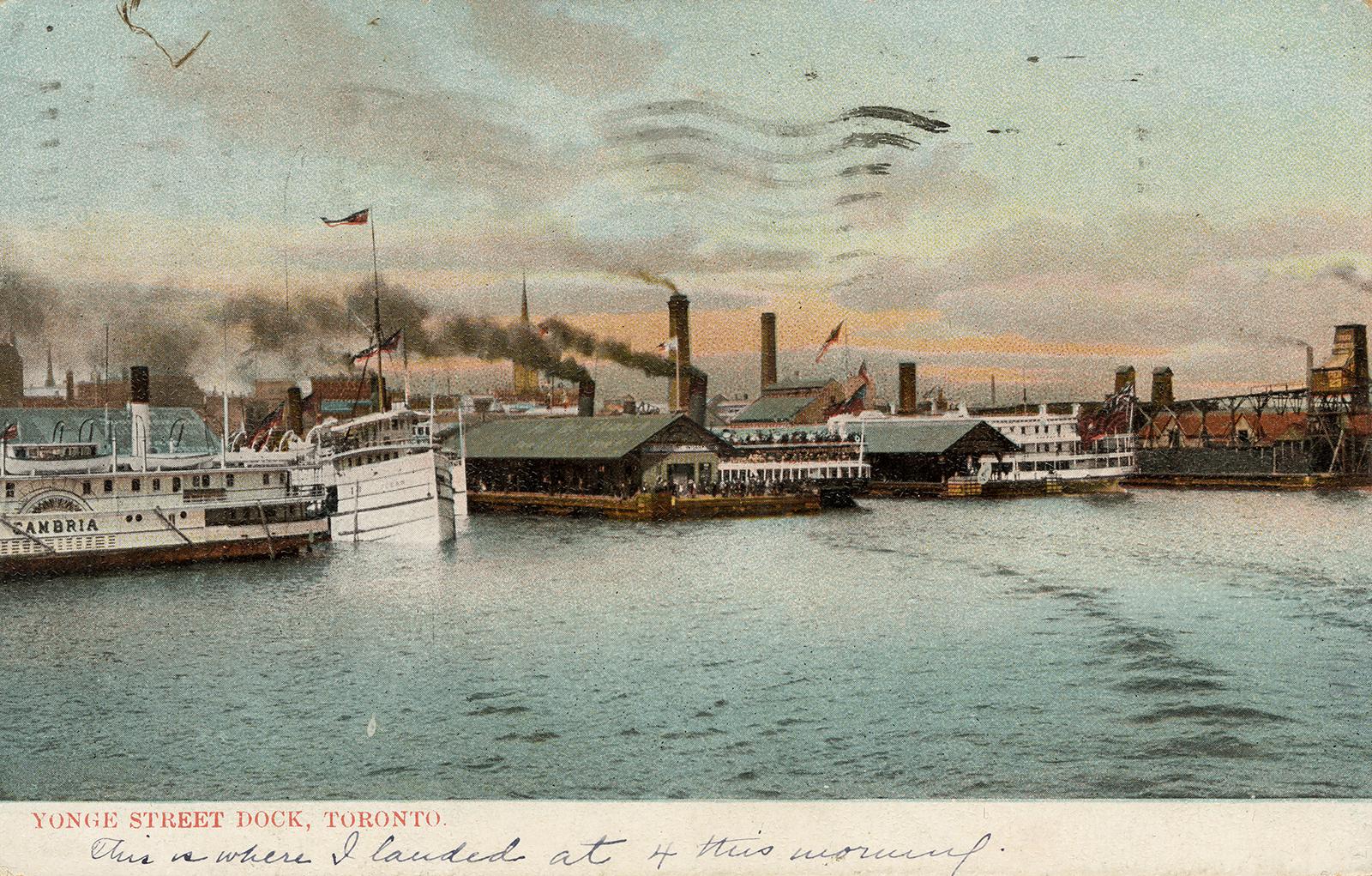 Colorized photograph of steam boats moored in front of busy docks on the shoreline of a large c…