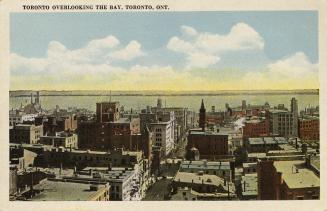 Color, aerial shot of tall skyscrapers of a city down town with a body of water in the backgrou…