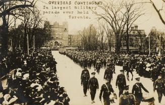 Black and white picture of soldiers marching on an icy city street while crowds of civilians lo…