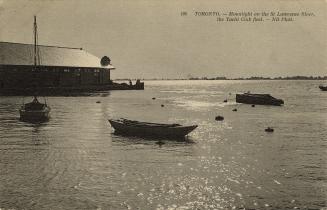 Black-white photo postcard depicting boats floating on the St. Lawrence river with the shore in…