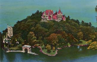 Color photograph of a aerial view of large, stone castle on an island in the middle of a waterw…