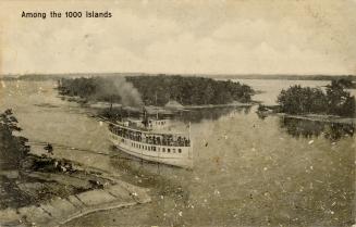 Black and white photograph of a steamboat loaded with passengers traveling up a body of water w…