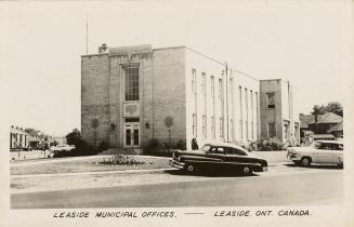 Black and white photo postcard depicting the exterior front of a building, with caption at the …