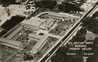 Black and white photo postcard depicting an aerial view of several buildings comprising a schoo…