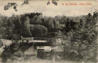 Black and white photograph of a bridge running over a river.