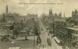 Black and white photo postcard depicting an an aerial view of Yonge Street with street cars and…