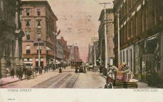 Colour photo postcard with a pink hue, depicting a view of Yonge Street looking north from sout…