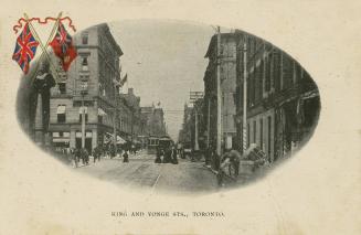 Black and white photo postcard with two coloured British / Union Jack flags on the top left of …