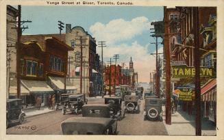 Colour postcard depicting a view of Yonge Street with many shops, cars, a streetcar, and pedest…