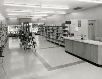 Interior view of library showing desk and shelves. 