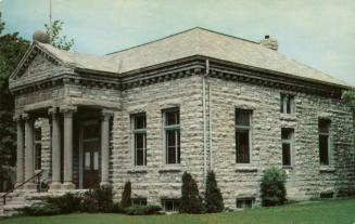 Picture of one storey stone library building with six pillars at entrance.