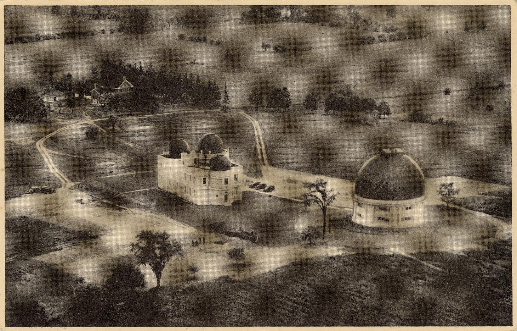 Black and white aerial photograph of a stone building with domes and one large domed building.