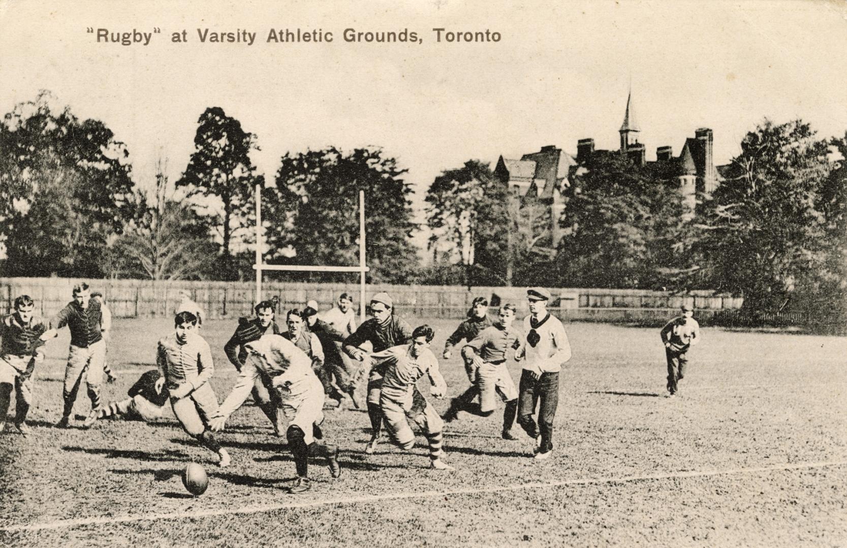 Black and white photo postcard depicting male rugby players in action. The caption at the top s…