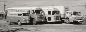 Picture of four bookmobiles in a parking lot arranged from the smallest (VW van) to largest tru…