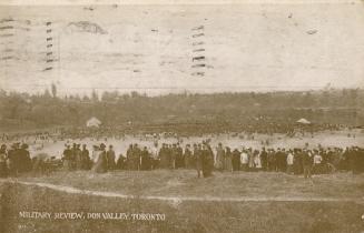 Sepia-toned photo postcard depicting many military personnel in a large field at Don Valley wit…