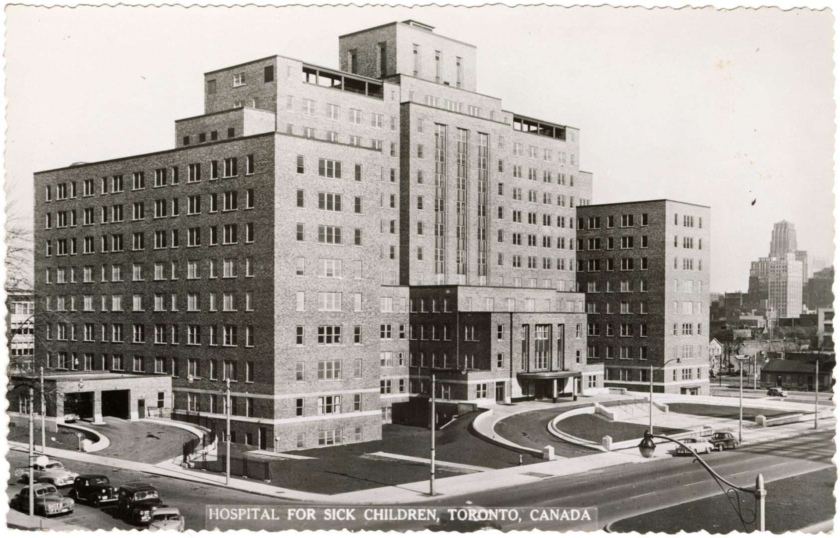 Black and white photo postcard depicting the exterior north-west facade of a hospital with two …