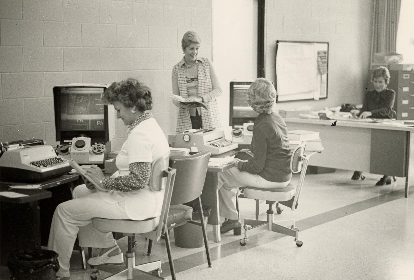 Picture of library staff working in an office seated at desks. 