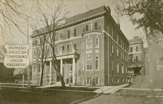 Black and white drawing of a large four story story building with balconies over two front door…