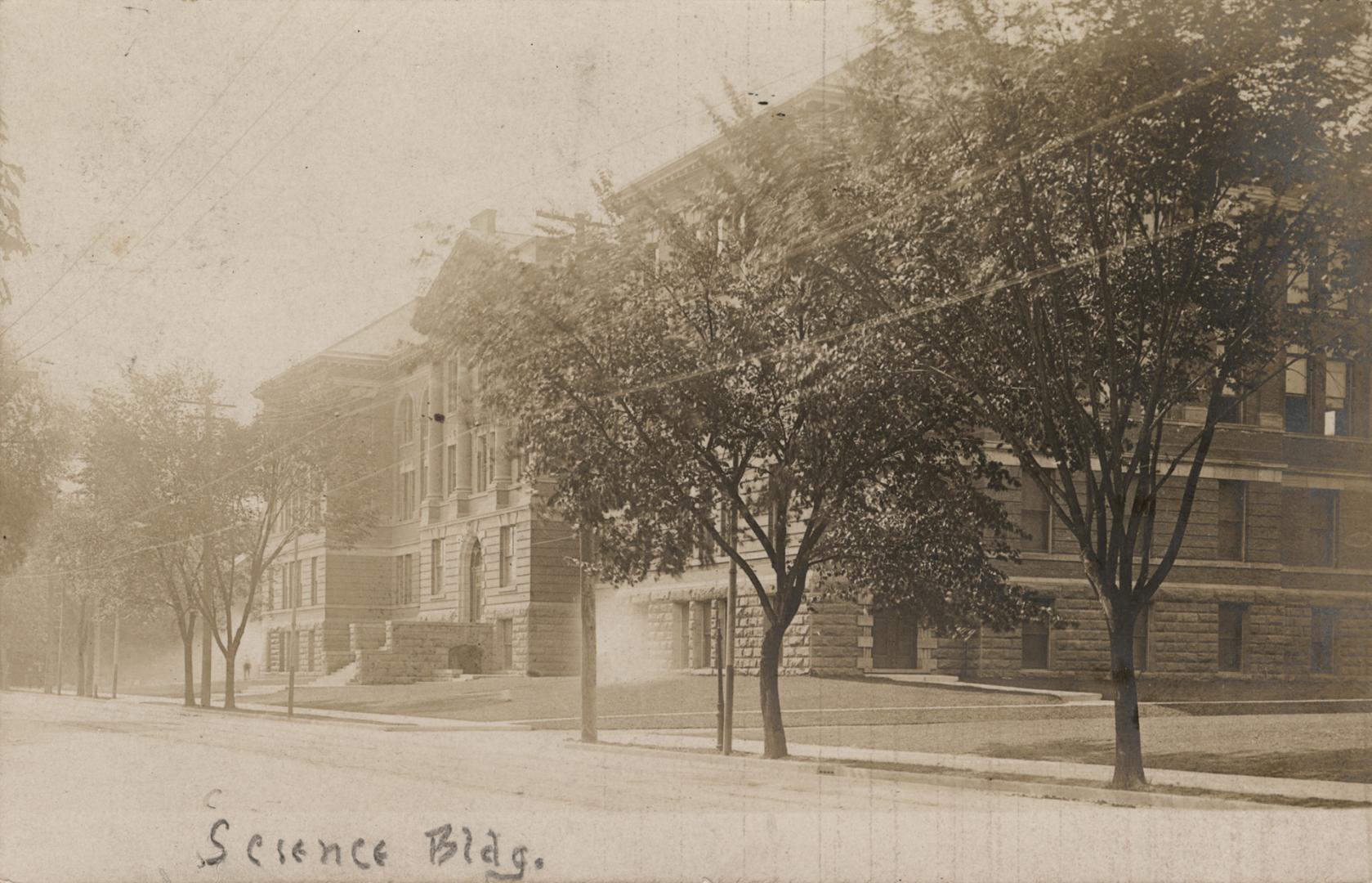 Sepia-toned photo postcard depicting the exterior frontage of a building. A handwritten caption…