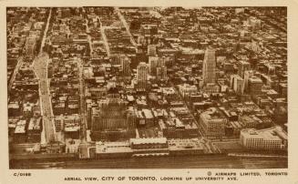 Sepia-toned photo postcard depicting an aerial view from the train tracks looking north. The ca…