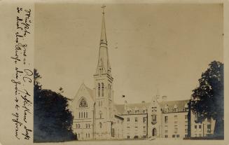 Sepia-toned photo postcard depicting the exterior of St. Basil's Church in Toronto. There is ha…