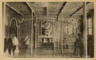 Black and photo postcard depicting a religious room with several nuns standing on the sides. Th…