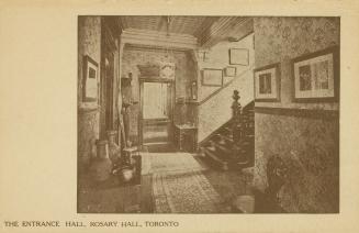 Sepia photo postcard depicting an inset photo of the entrance hall of a women's hostel, decorat…