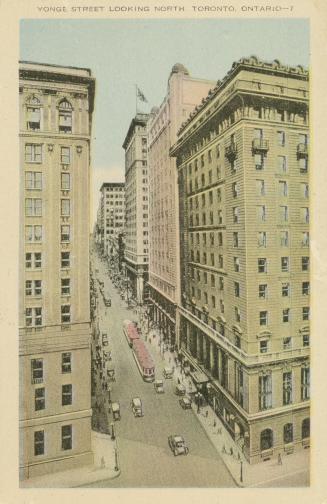 Colour postcard depicting a view of Yonge St. from above, with some buildings, retail shops, pe…